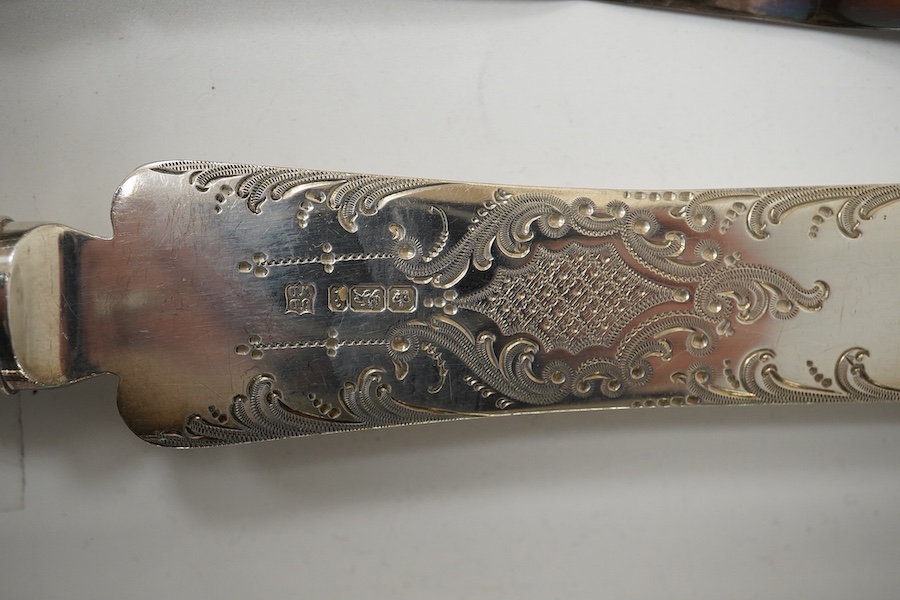 An Edwardian silver cake knife with engraved blade and decorative handle, James Deakin & Sons, Sheffield, 1901, together with a late Victorian silver handled button hook and silver handled shoe horn. Condition - poor to